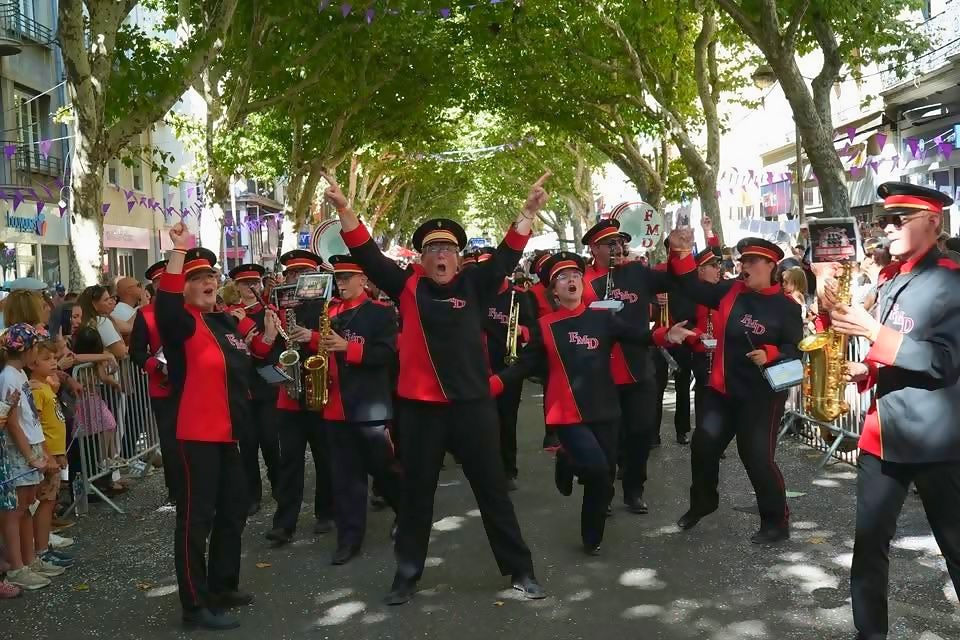 Le band défile sur une avenue, sourires et instruments levés