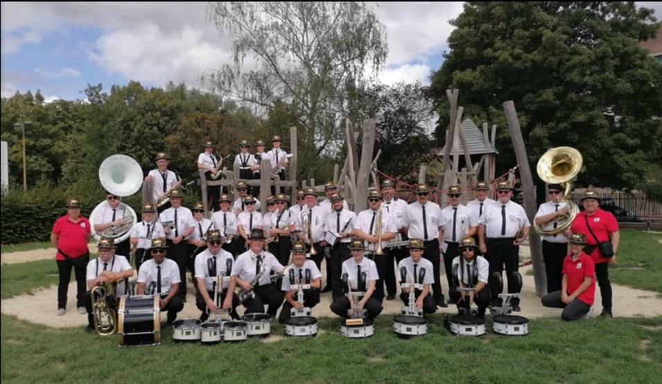Les musiciens en chemises blanches et chapeaux, avec sousaphones et caisses claires