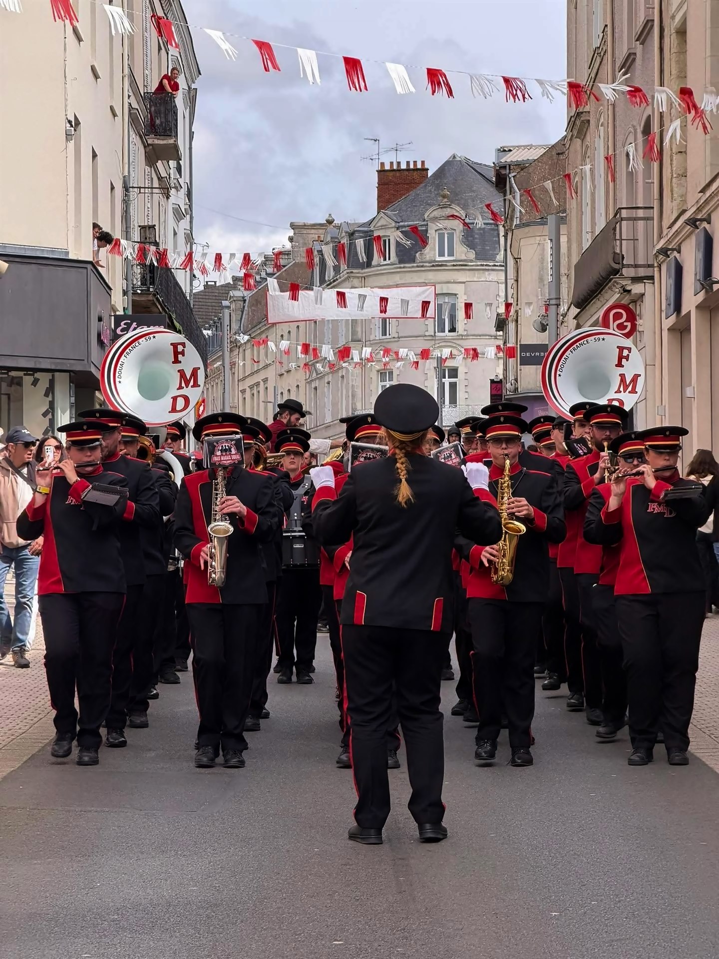 Le band défile dans une rue pavoisée